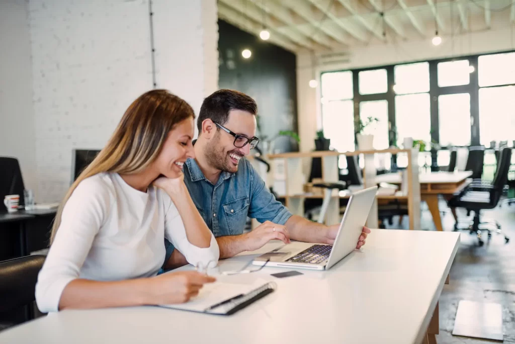 Profesional extranjero trabajando en México con laptop en un coworking moderno.