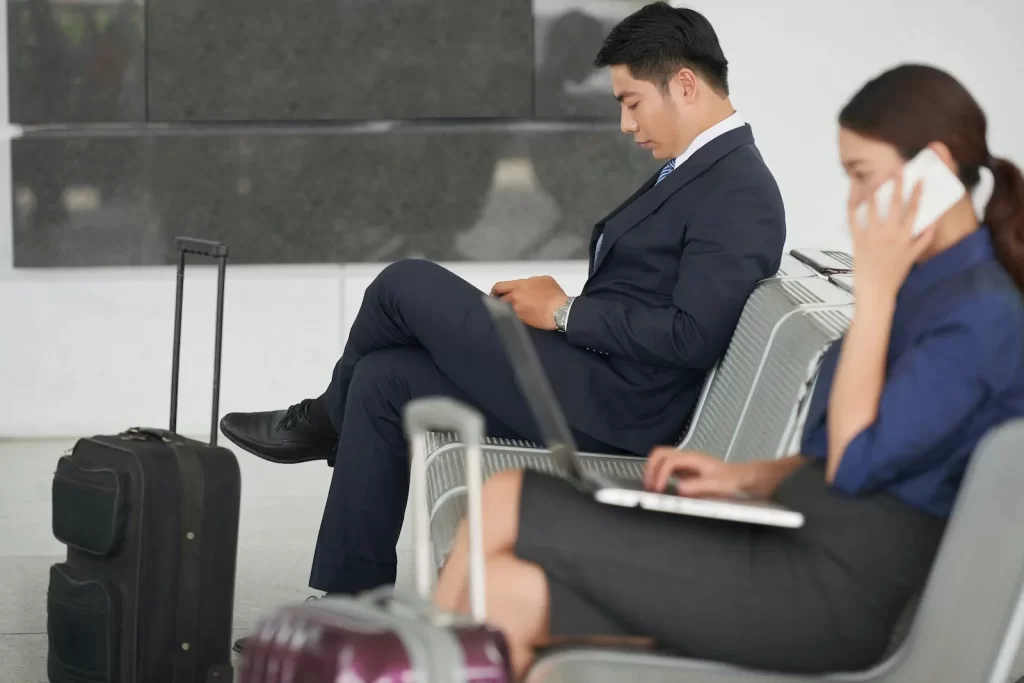 Hombre de negocios esperando vuelo mientras trabaja, listo para viajar a China