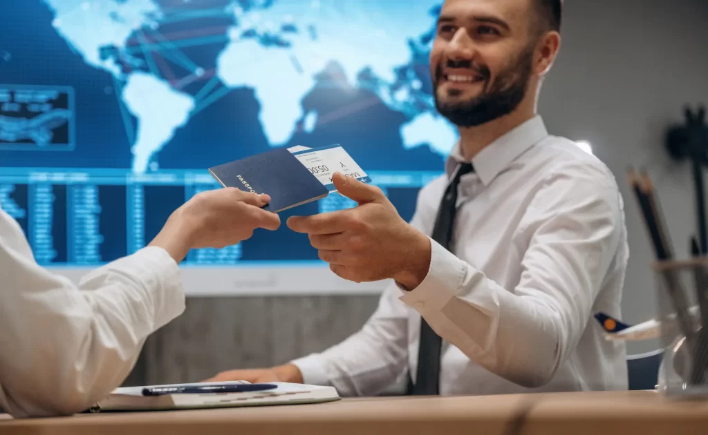Ejecutivos conversando sobre viaje de negocios frente a pantalla con mapa mundial.