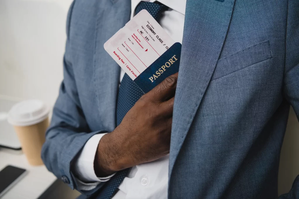 Hombre de negocios guardando pasaporte y boleto en el bolsillo de su saco.