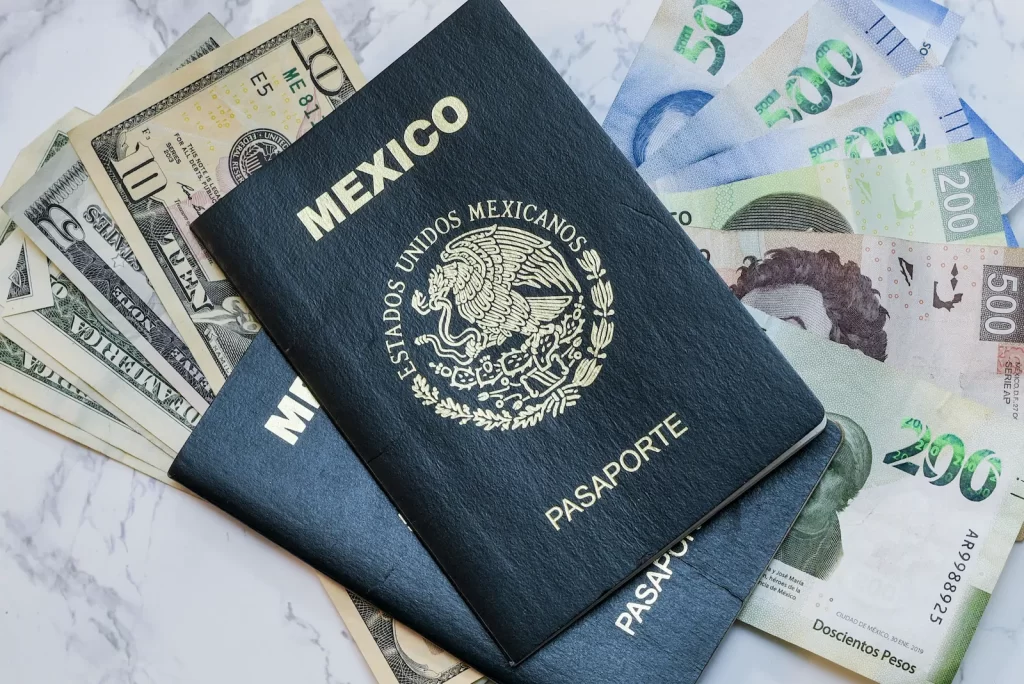 Pasaportes mexicanos junto a billetes, representando costos y documentación para residencia en México