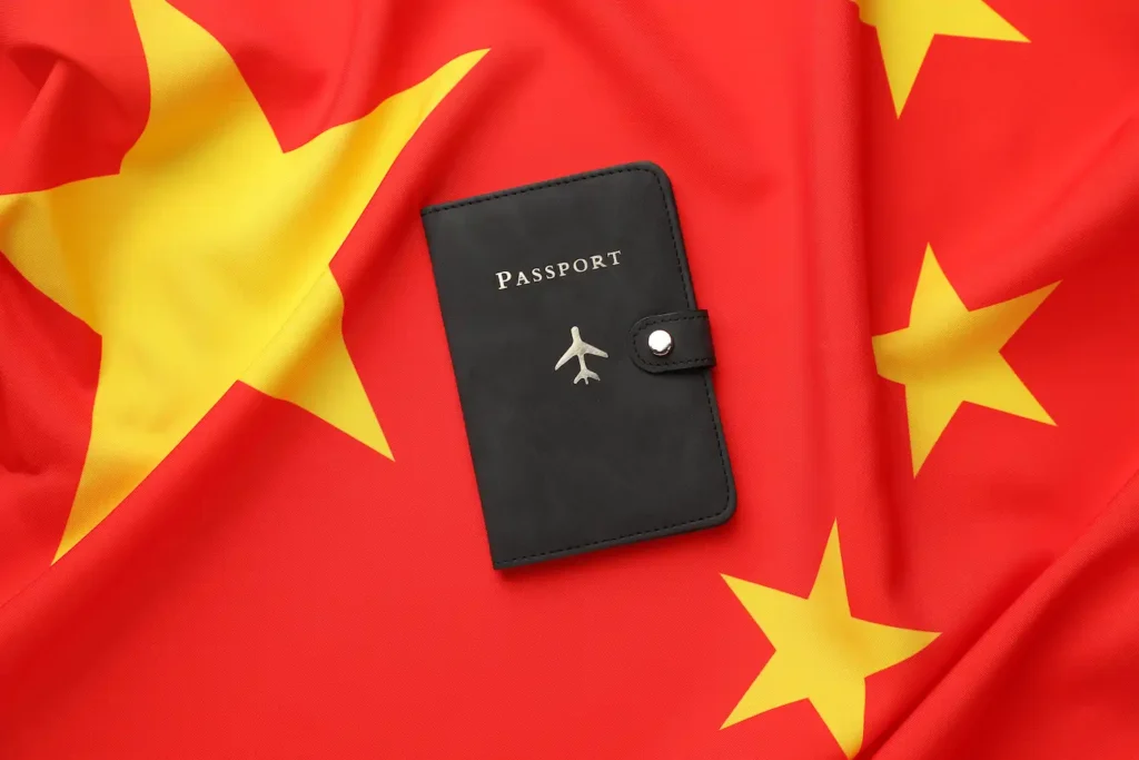 Pasaporte negro sobre bandera de China con estrella amarilla