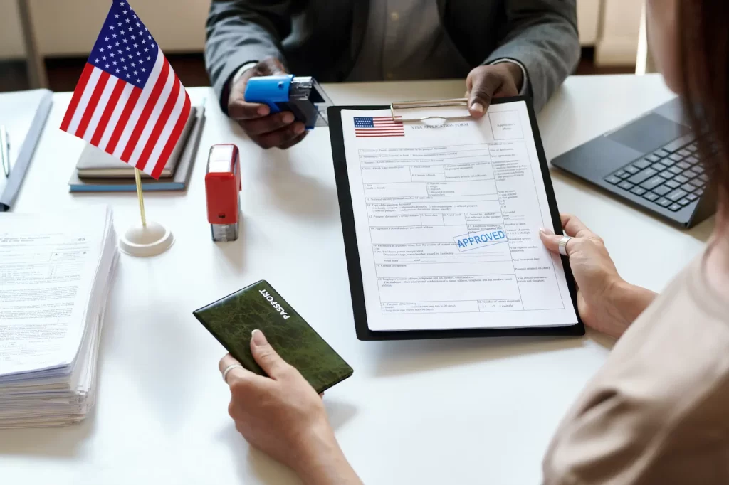 Asesor revisando formulario de visa con bandera de Estados Unidos