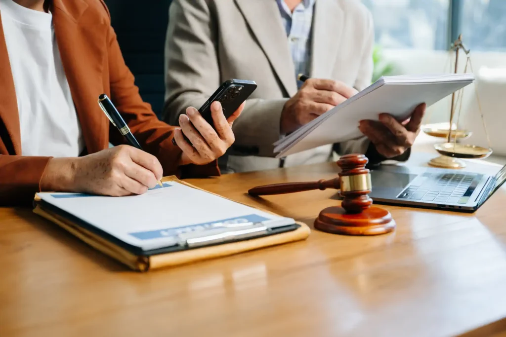Abogados revisando documentos con mazo y móvil