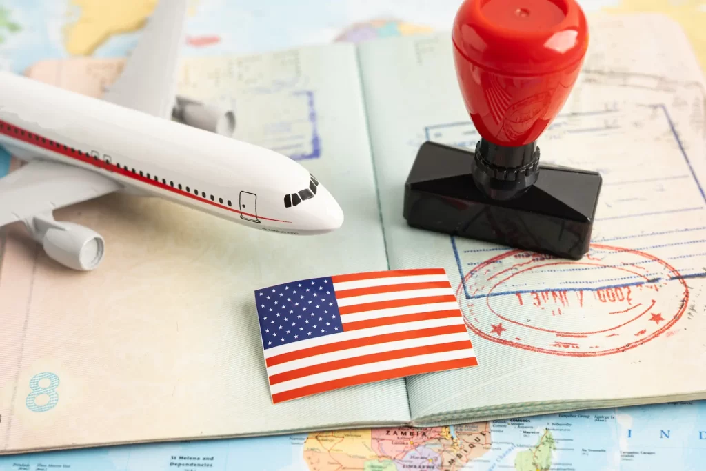 Avión en maqueta sobre un mapa con bandera de EE.UU., ilustrando viajes con visa próxima a vencer.