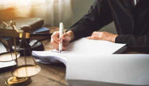 Abogado firmando documentos junto a mazo judicial