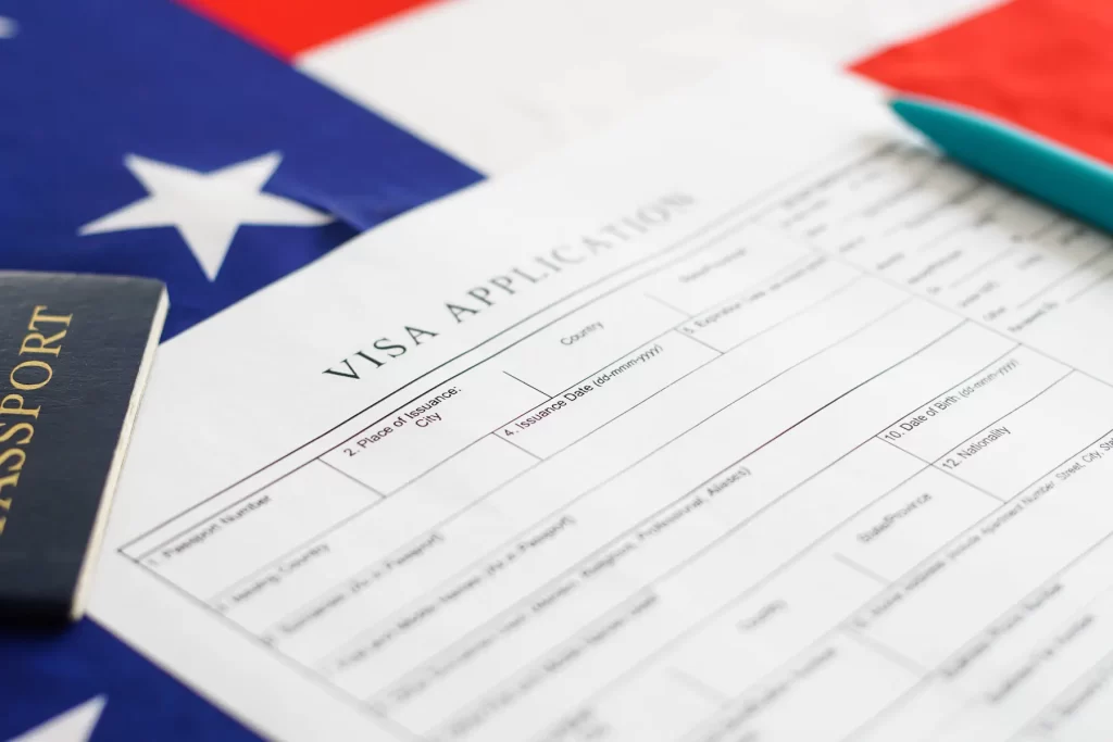 Formulario de solicitud de visa estadounidense sobre fondo de bandera de Estados Unidos