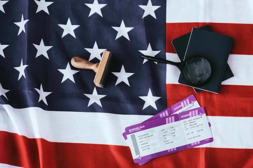 Pasaporte y documentos de viaje colocados sobre la bandera de Estados Unidos