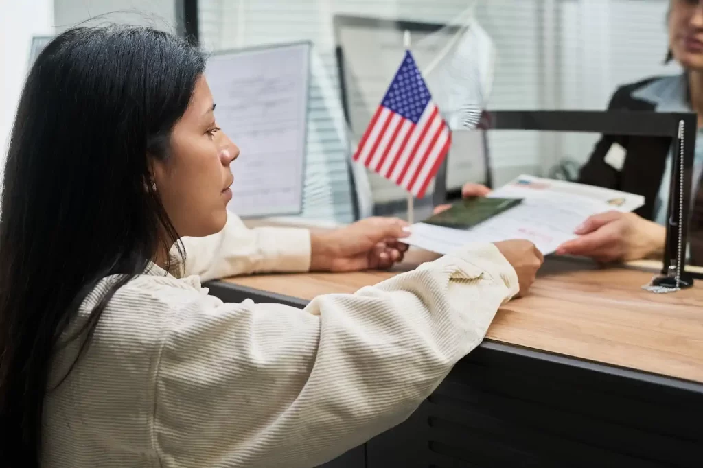 Persona en entrevista consular para renovar visa americana con oficial revisando documentos