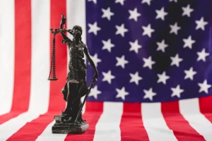 Estatua de la Justicia frente a bandera estadounidense