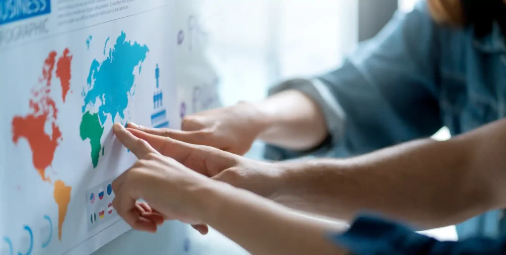 Manos colocando gráfico sobre mapa mundial en pared