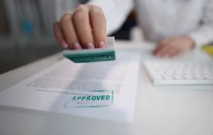 Mano sellando documento con sello de aprobado